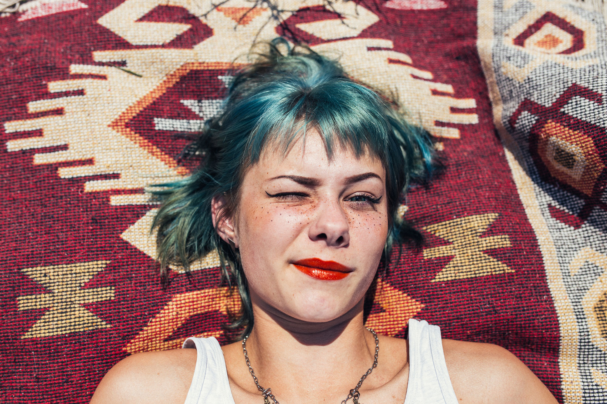 Girl with green hair laying on blanket